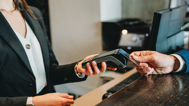 Business traveler making a payment with a card machine